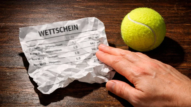 Zerknüllter Wettschein neben einem Tennisball auf einem Tisch