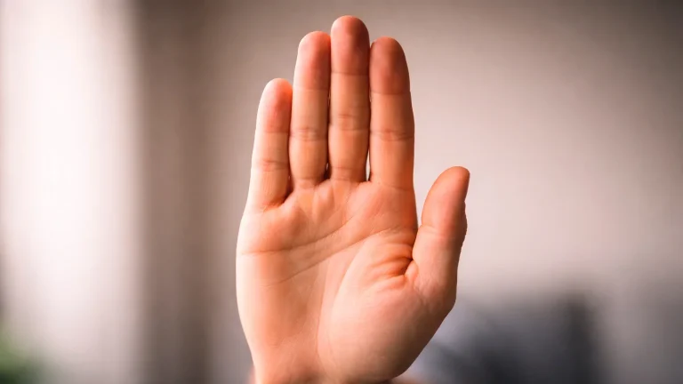 Offene Hand mit Stoppzeichen-Geste vor einem unscharfen Hintergrund